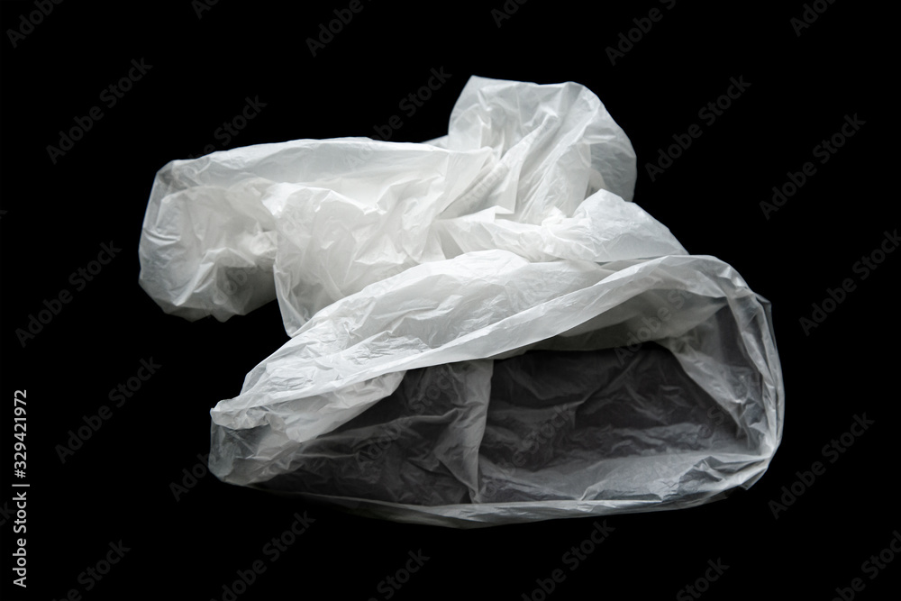 Empty crumpled plastic bag isolated on a black background. Used plastic bag is intended for recycling. Recycling of plastic waste into pellets as a business.