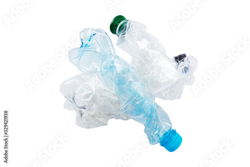 Flattened empty used plastic PVC bottles isolated on white background. Crumpled bottle - recycle eco concept. The used plastic bottles may be recyclable.