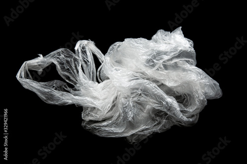 Empty crumpled plastic bag with handles isolated on a black background. Used plastic bag for recycling. Recycling of plastic waste into pellets as a business.