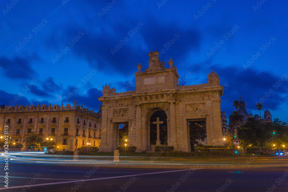 Puerta del Mar Triumphal Arch at blue hour with car light trails in Valencia, Spain