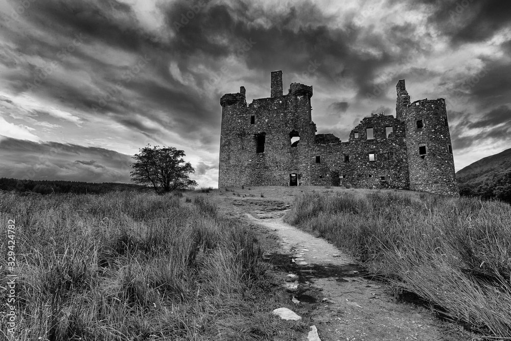 Kilchurn Castle in Scottish Highlands landscape after rain in monochrome