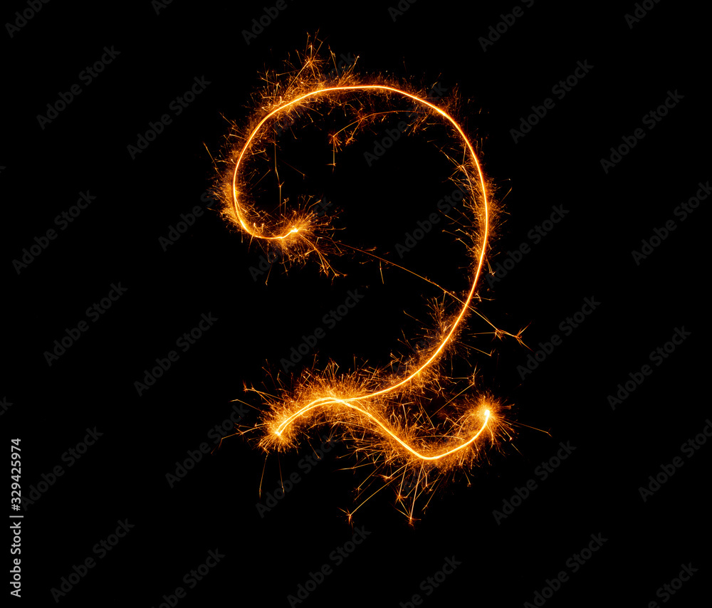number two written with a sparkler on a black background