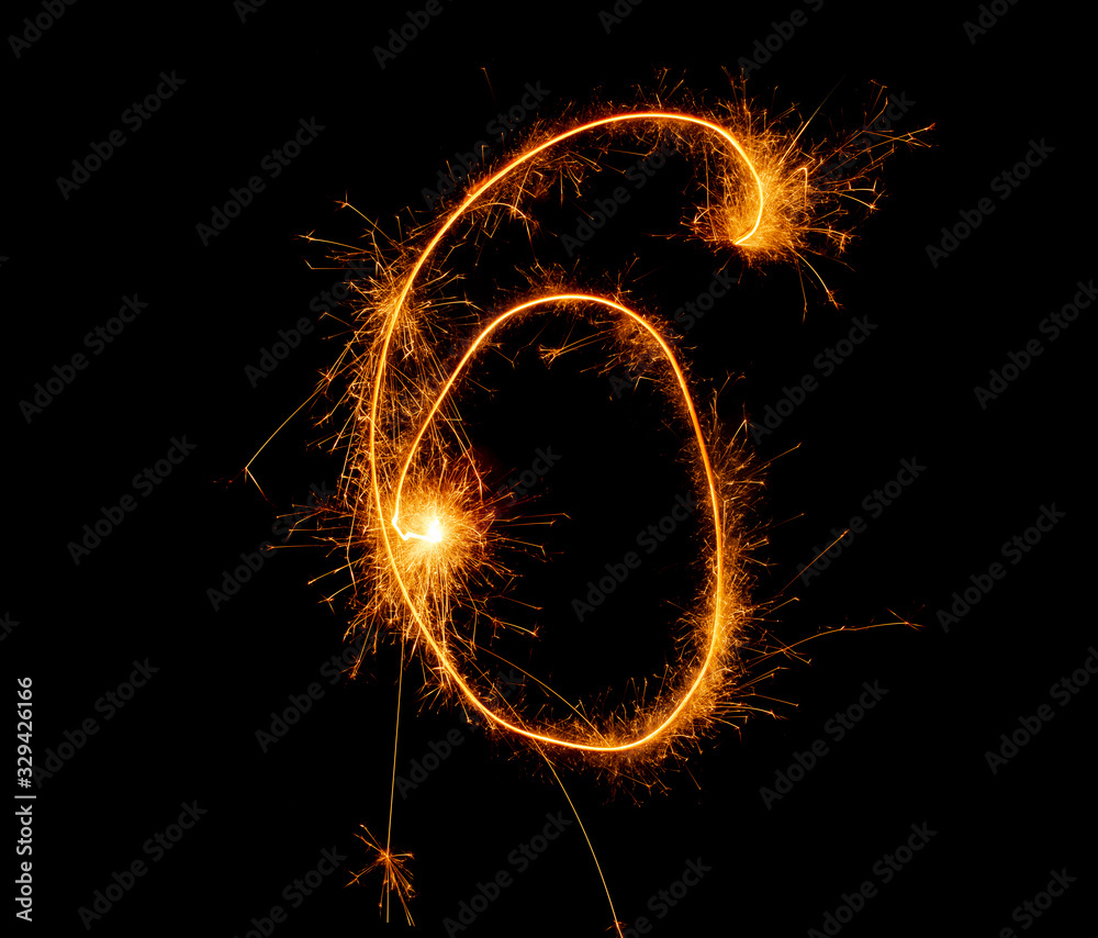 number six written with a sparkler on a black background