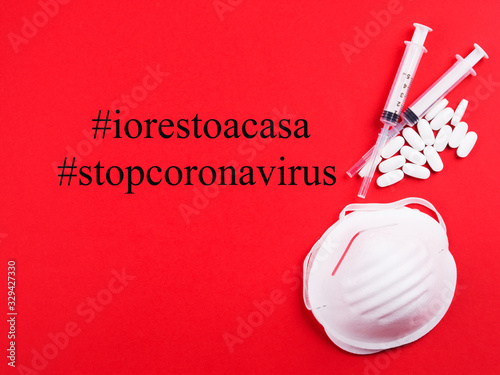 Hashtag I stay at home, Italian government civil responsibility camapaign launched on March,9. Coronavirus SARS-cov2 epidemic prevention. Treatment concept with masks, syringes and antibiotic on blue photo