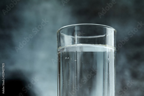 Tapet Glass of pure water on the grey background