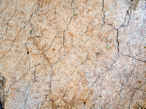 Old beige marble slab whole in cracks. Marble wet from the rain. Stone background.