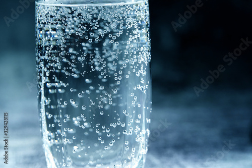 Glass of sparkling water on the grey background