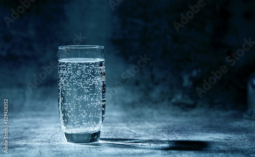 Tableau sur toile Glass of sparkling water on the grey background