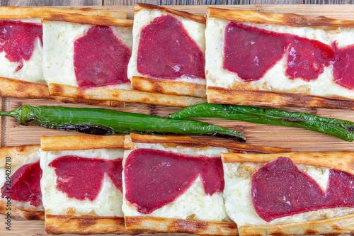 Turkish name; Pastirmali Kasar peynirli pide. Turkish style pide with long roasted and pastrami pita. Baked in stone oven with cheddar cheese. photo