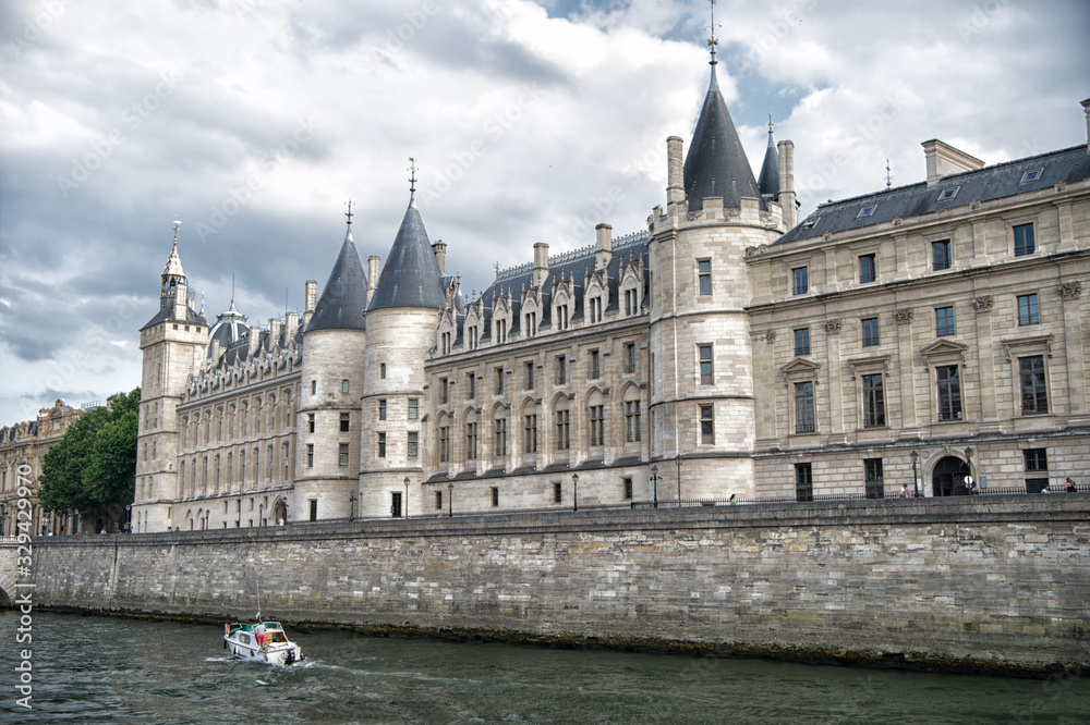 Palace on stone embankment. Boat tour. Palais de la Cite in Paris France. Palace building with towers and spires. Monument of gothic architecture and design. Vacation and wanderlust in french capital