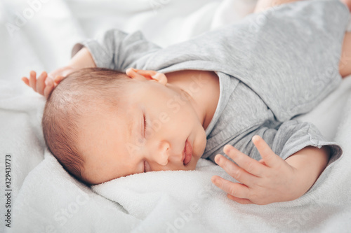 Sleeping newborn baby boy in bed