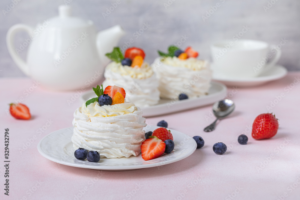 Pavlova meringue cake with fresh berries on pink background Pavlova meringue cake with fresh berries on pink background
