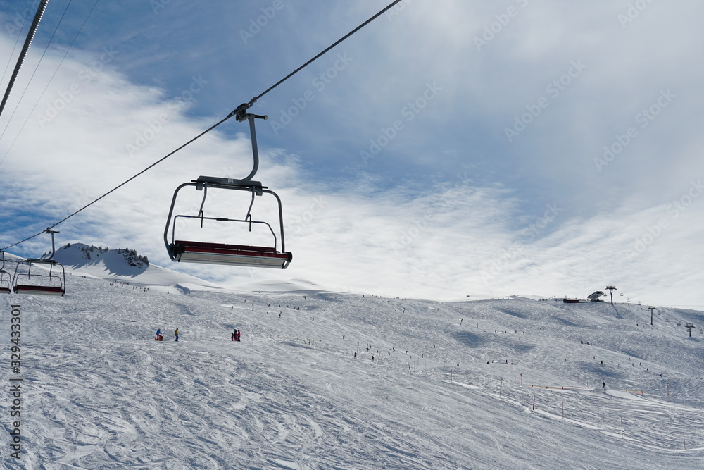 Empty chair lifts in ski resort Switzerland closing up because of corona virus. The last skiers are on the slope. The resort is more or less abandoned due to official ban of ski resorts operation Empty chair lifts in ski resort Switzerland closing up because of corona virus. The last skiers are on the slope. The resort is more or less abandoned due to official ban of ski resorts operation