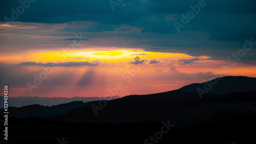 Amazing sunset with cloudy sly and the silhouette from hills in the black forest © Corri Seizinger