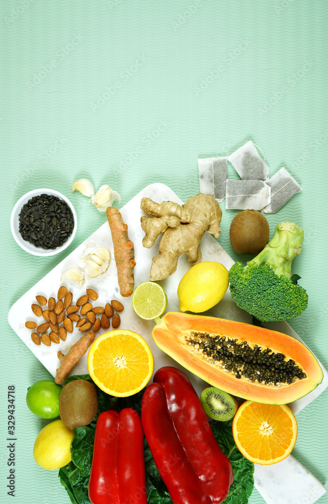 Foods that boost the Immune System. Citrus, red bell peppers, broccoli, garlic, ginger, spinach, almonds, turmeric, green tea, papaya, kiwi fruit, poultry and sunflower seeds. Negative copy space. Foods that boost the Immune System. Citrus, red bell peppers, broccoli, garlic, ginger, spinach, almonds, turmeric, green tea, papaya, kiwi fruit, poultry and sunflower seeds. Negative copy space.