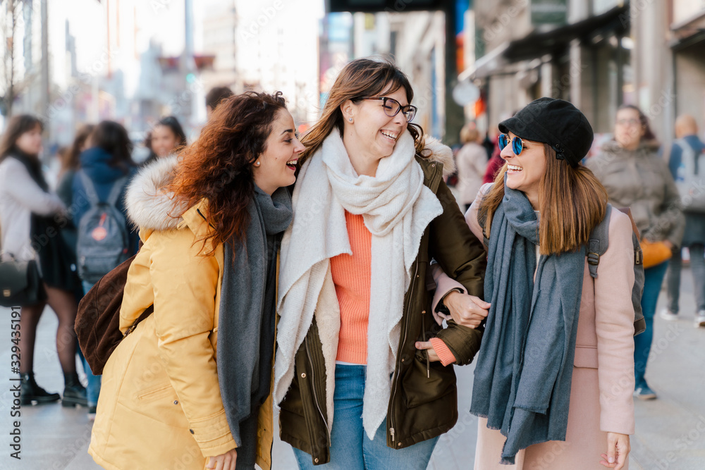 Group of european tourist sightseeing in Madrid, the capital of Spain. Travel and holidays concept. People lifestyle in urban cities, shopping, and visit cultures. Women walking the street in winter.