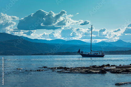 Sailboat in the ocean with mountains on Vancouver island Salish sea