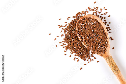 Flax grains, spices in a wooden spoon on a white background. Concept, copy space.