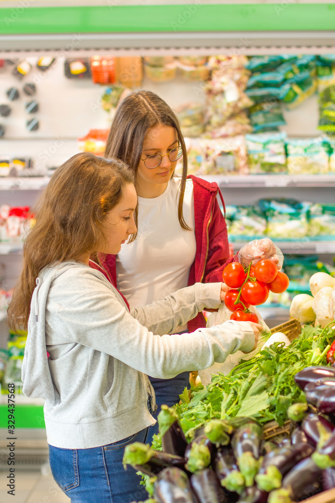 Teen girls shopping supermarket. Young people make the conscious, organic and healthy choice.