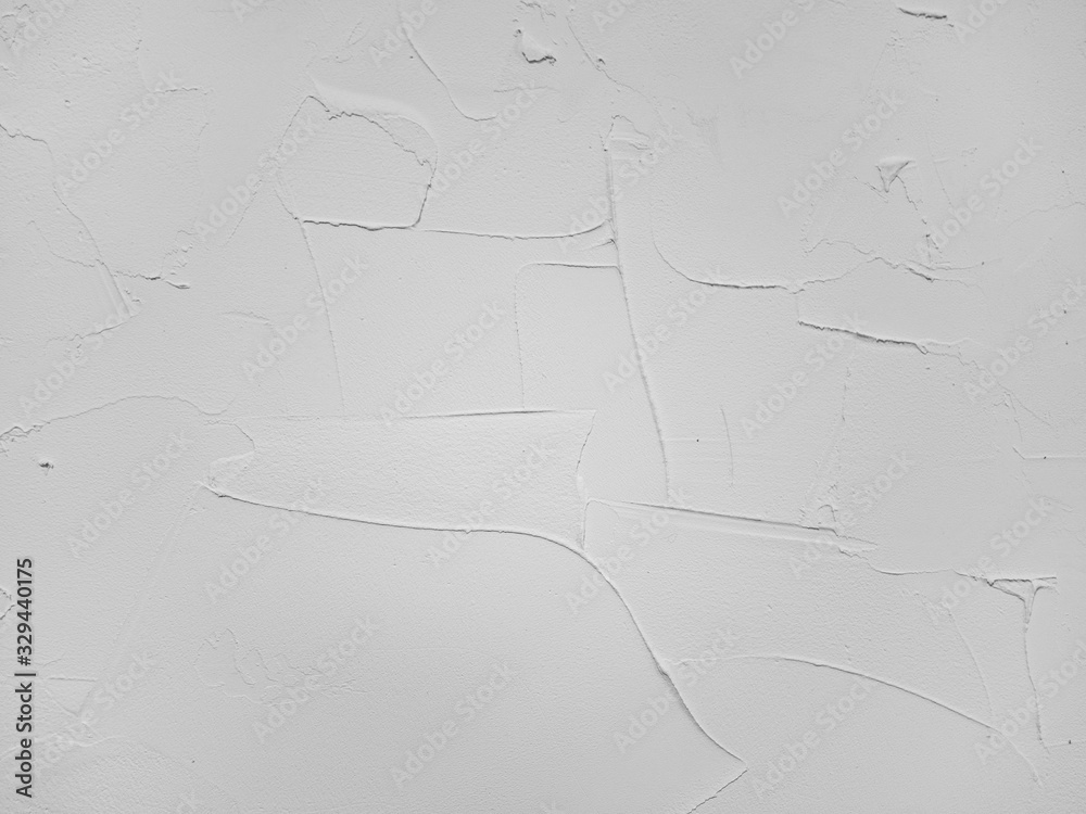 Closeup of white decorative stucco. Rough strokes. Textured pattern. Traces of a spatula. Wallpaper. Background