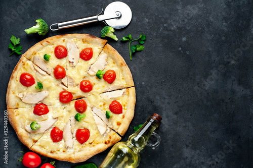 delicious pizza with pineapple, broccoli, tomatoes, mozzarella cheese, chicken fillet on a stone background with copy space for your text