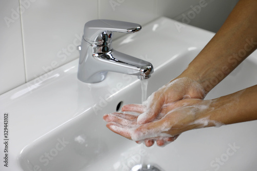 COVID-19 Washing hands with soap under the faucet with water against Novel coronavirus (2019-nCoV). Antiseptic, Hygiene and Healthcare concept.