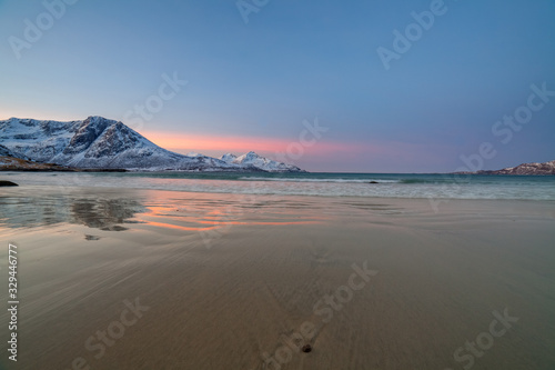 sunrise with amazing magenta color over sand beach and fjord. Tromso, Norway. Winter. Polar night. long shutter speed