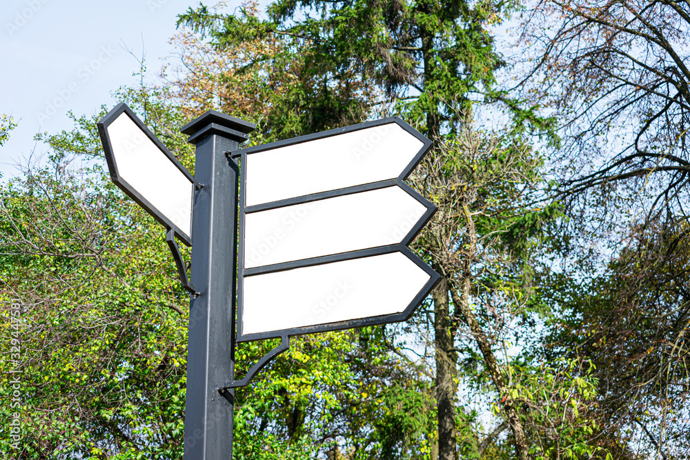 Directional road signs on the street. Black metal arrows on the ...