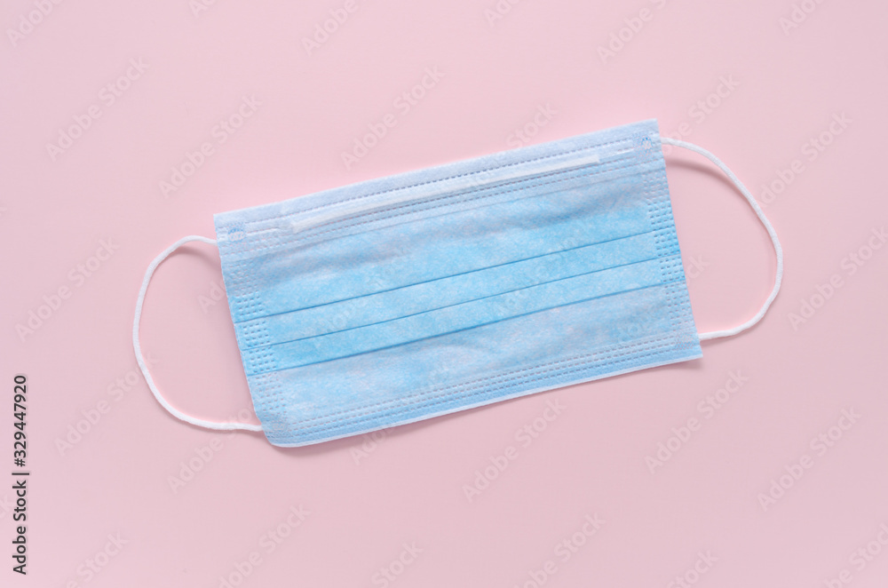 medical mask pink color to cover the mouth and nose for protection from bacteria on a pink background. space for text