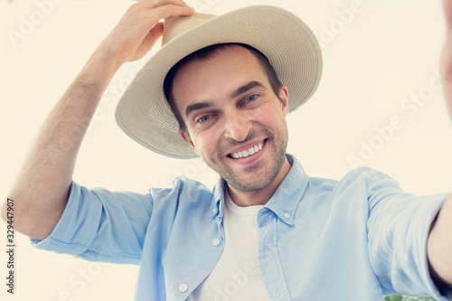 Attractive man communicates on Skype, greets his interlocutor and takes off his hat, portrait, toned photo