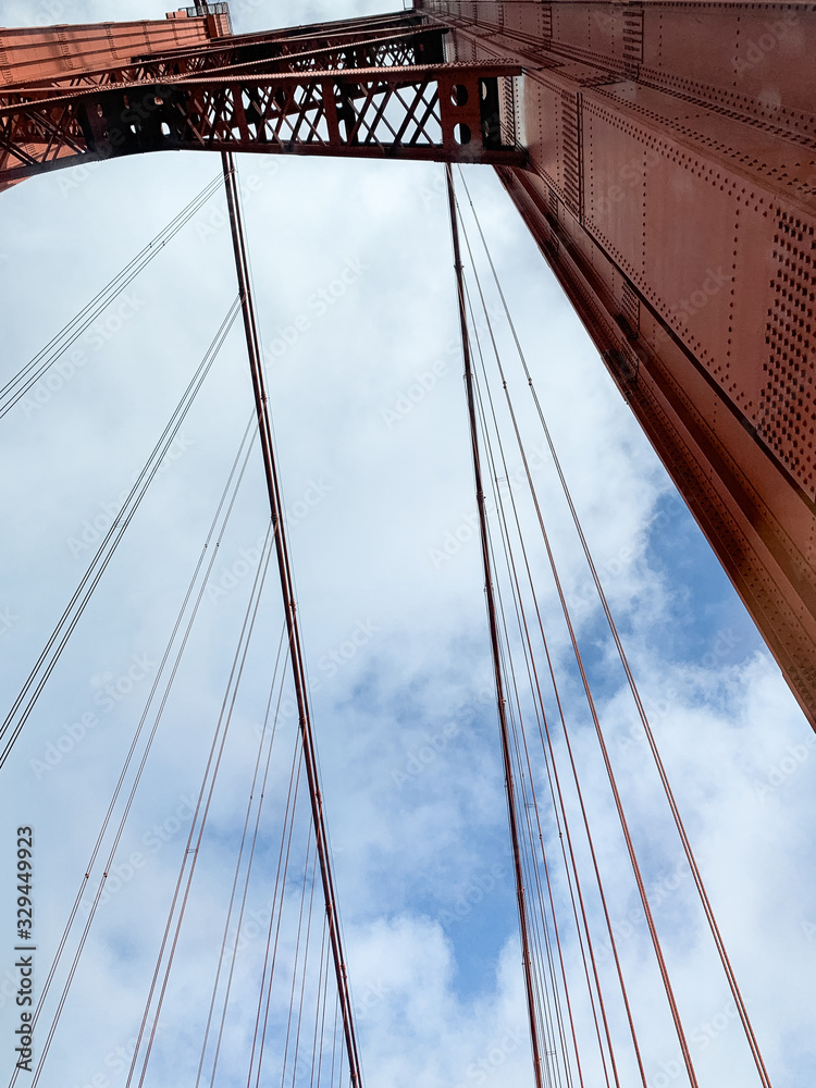 Fototapeta premium Suspension bridge Ponte 25 de Abril with Lisbon behind the bridge. Cross the Tagus river from Lisbon to Almada.