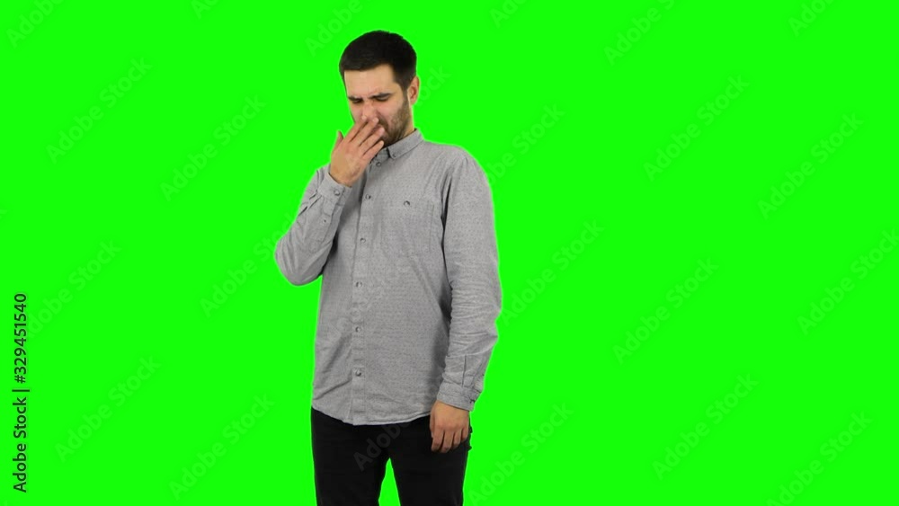 Brunette guy is showing disgust for bad smell or taste. Green screen Brunette guy is showing disgust for bad smell or taste. Green screen
