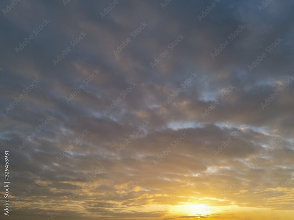 Sunset sky with clouds and sun flare. Abstract nature background.