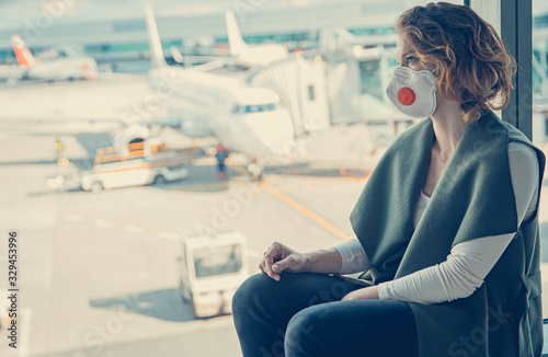 woman waiting for check-in in the airport lobby. The use of respirators for protection against viruses photo