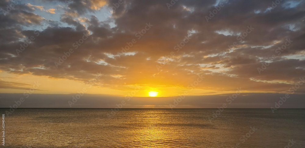 Abstract seascape panoramic background - Orange color in the sky, sunset late afternoon. Calm seas/ocean in the bottom of the frame. Minimalistic simple background image, blue and yellow colors.