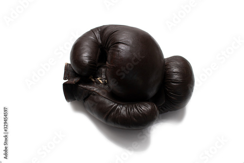 Two leather brown brown boxing gloves lying on top of each other isolate