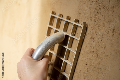Closeup of a plasterer finishing a wall made of clay plaster with a board