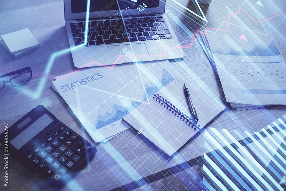 Financial graph colorful drawing and table with computer on background. Double exposure. Concept of international markets. Financial graph colorful drawing and table with computer on background. Double exposure. Concept of international markets.