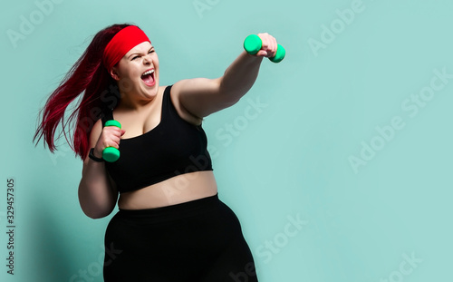 Fitness spring diet weight loss concept. Lucky plus-size girl overweight woman dieting working out with green weights dumbbells