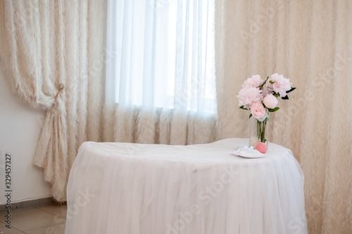 White table with bouquet of flowers in vase