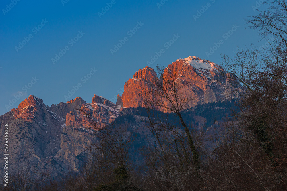 Wonderful sunset on the walls of Monte Pizzocco with the top covered with snow, Dolomites, Italy. Concept: dolomitic landscape, sunset on the dolomites, beauty of the dolomites