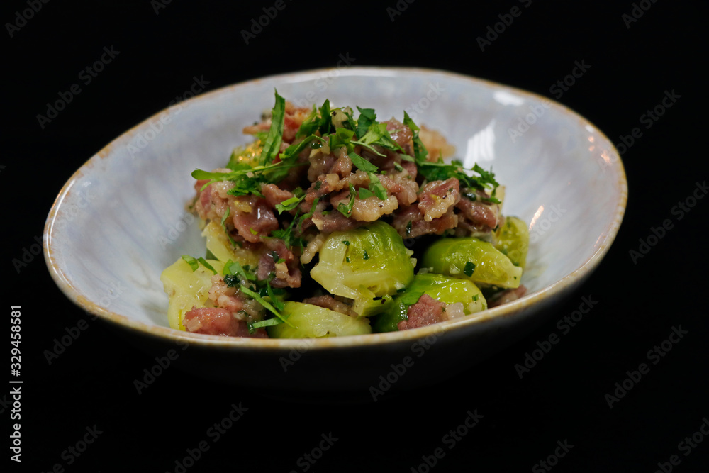 cooked Brussels sprout with beef bacon in a serving bowl with black background cooked Brussels sprout with beef bacon in a serving bowl with black background