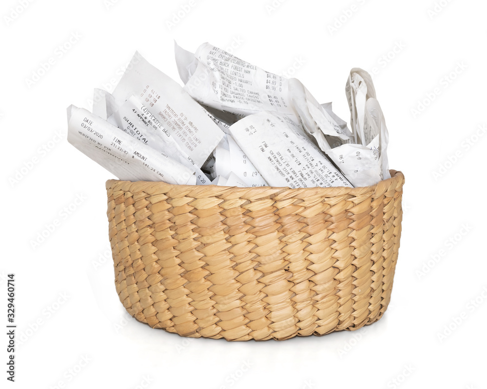 Obraz premium Stuffed storage basket of receipts for filing taxes and deductibles. Straw container with many crumbled papers. Isolated on white.
