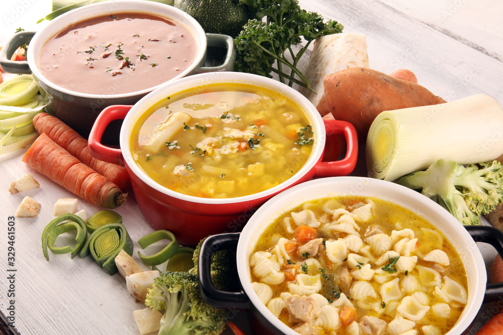 Set of soups from worldwide cuisines, healthy food. Broth with noodles, beef soup and broth with marrow dumplings. All soups with healthy vegetables on table - obrazy, fototapety, plakaty 