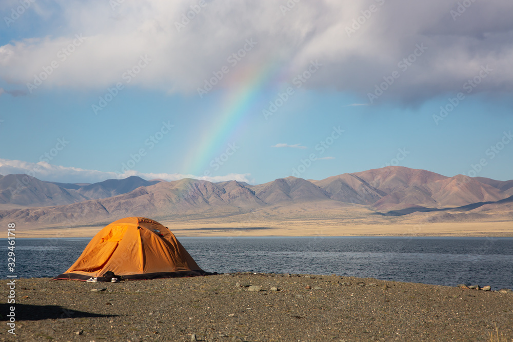 Cloudy view on a mountain lake. Mongolia tent at beach