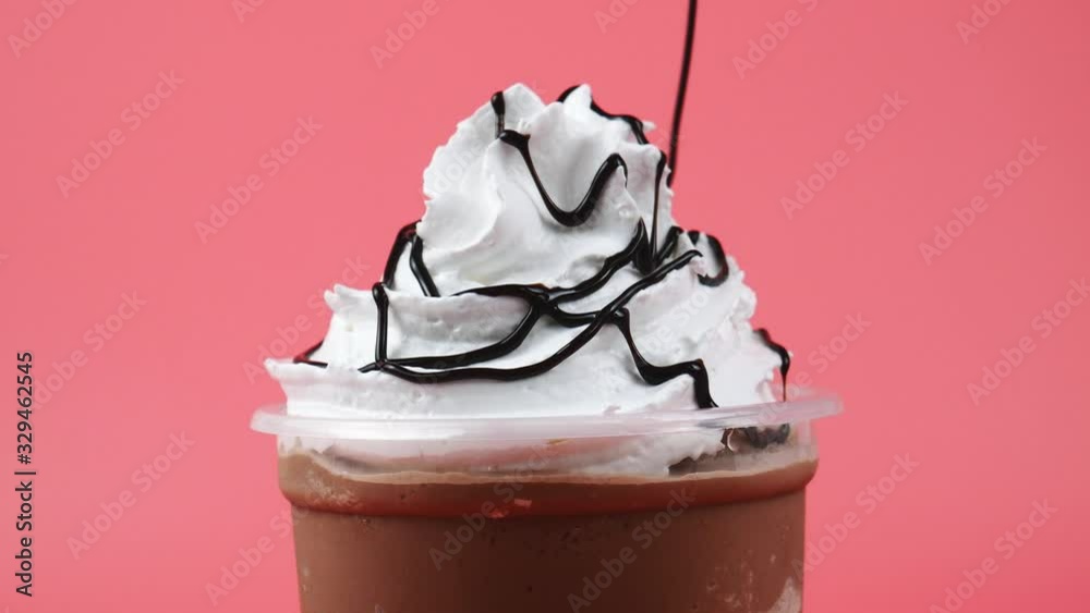 Chocolate sauce topped whip cream Cocoa smoothie on pink background, Food concept Front view.