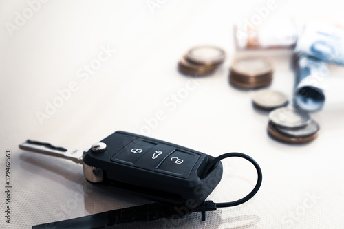 car key and coins on white background, concept photo for car finance industry