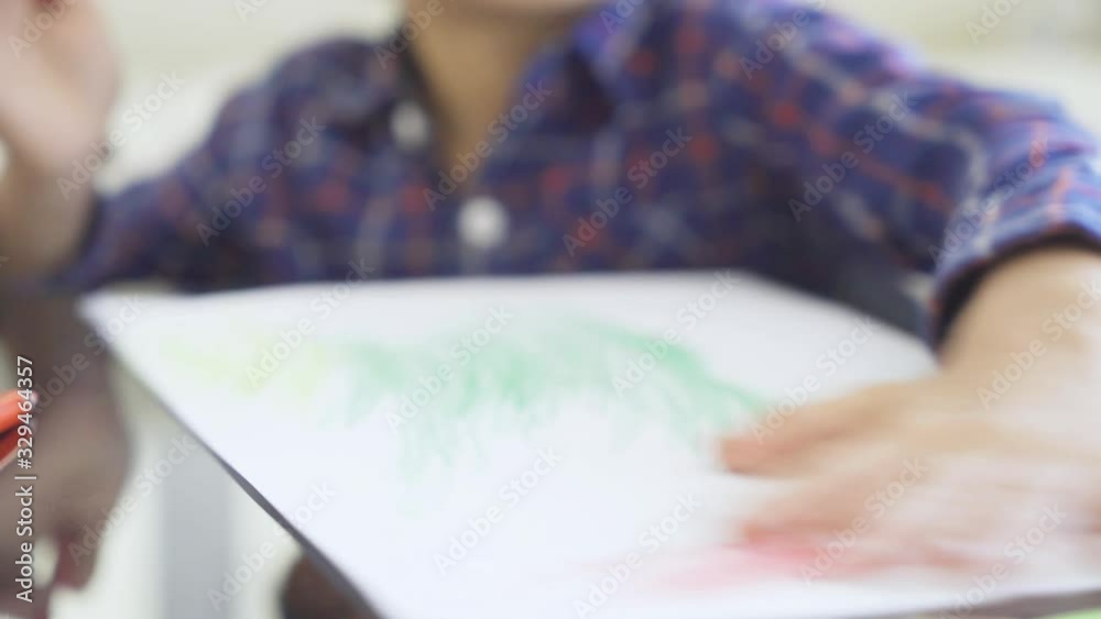 Closeup of little boy hands coloring on a paper Closeup of little boy hands coloring on a paper
