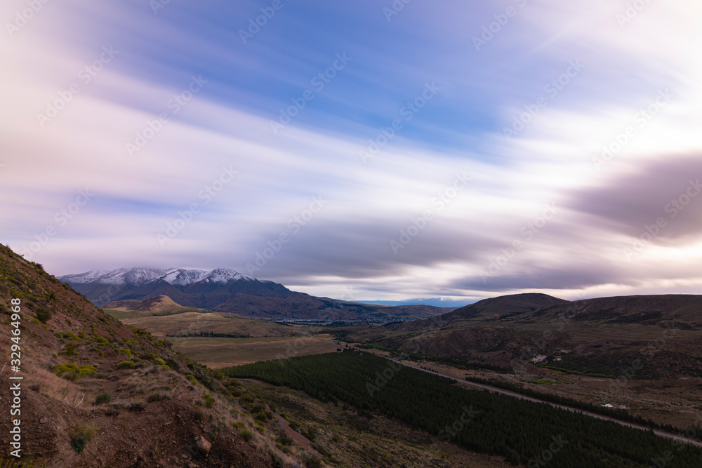 Long exposure shot of Patagonian landscape with snow-capped mountains and blue sky in Esquel, Patagonia, Argentina