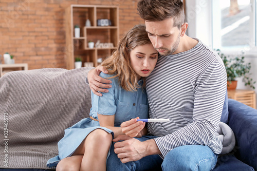 Sad young couple with pregn...